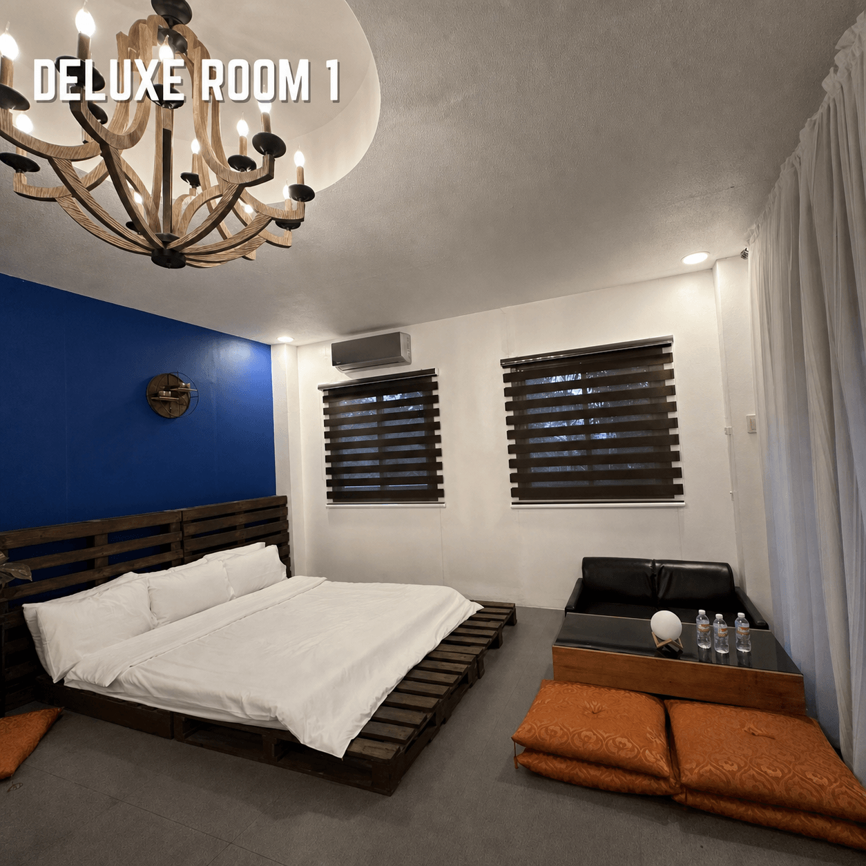 Nokori Deluxe Room with a low wooden bed and lounge area